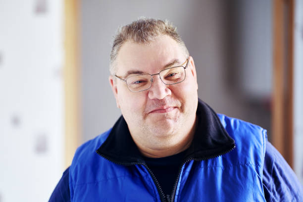 istock Fat man tries to hold back smile on his cheeky face. 2000597627