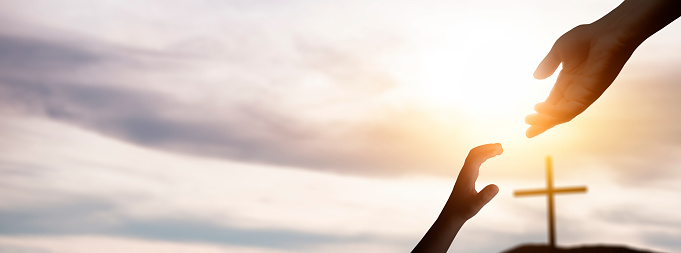 a christian cross symbol silhouette at sunset sunrise. 