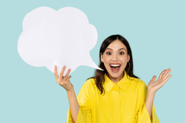 istock Emotional young woman holding communication bubble, blue background 2000619410