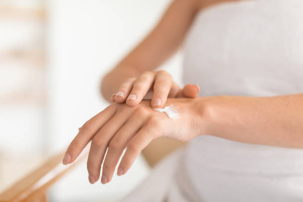 istock Closeup of woman's hands apply moisturizer cream in modern bathroom 2000632824