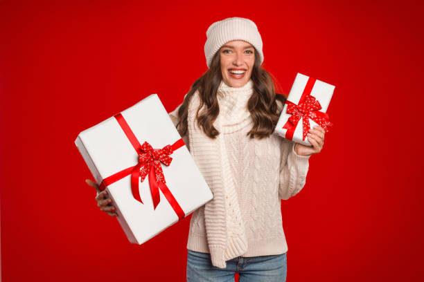 istock Happy lady posing with Christmas wrapped gifts boxes in studio 2000639202