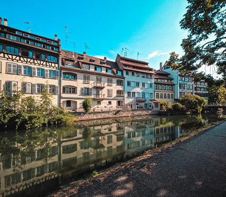 Looking out over a canal to historical medieval architecture in Strasbourg, France on a beautiful Summer day. Located in the La Petite area. A UNESCO World Heritage Site.