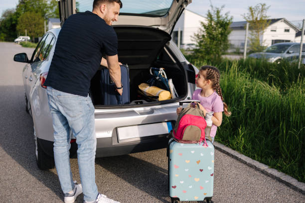 istock Father help daughter loading to the trunk with luggage before traveling while mom packs her luggage 2000659199