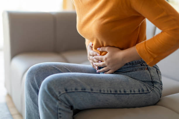 istock Unrecognizable woman experiencing abdominal pain at home, touching her stomach 2000663500