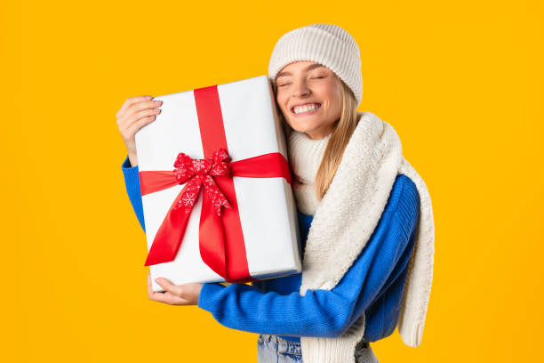 istock Joyful woman hugging a large gift with a bow 2000665195