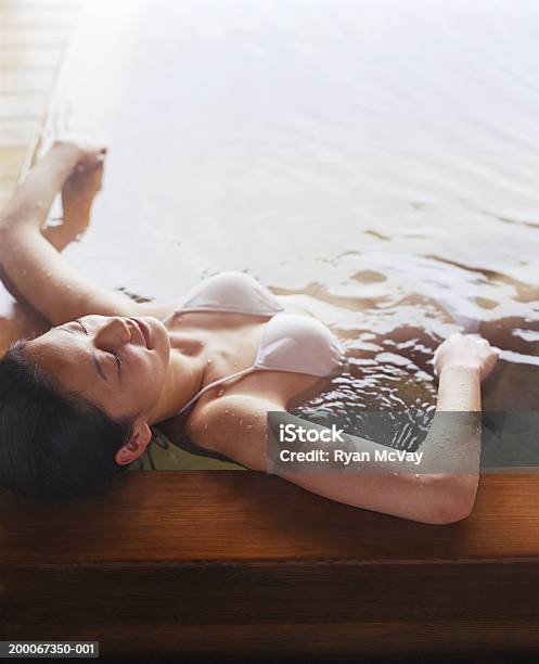 Young Woman Soaking In Hot Spring Bath Eyes Closed Elevated View Stock Photo - Download Image Now