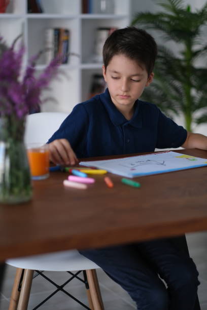 istock little boy painting on paper 2000681207
