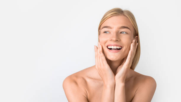 istock Attractive happy caucasian lady touching her face against white backdrop 2000687247