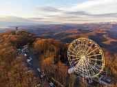 The Ferris wheel and observation tower with mountains in the background.