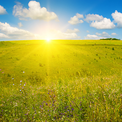 Hilly landscape, picturesque meadows and a vibrant sunrise.