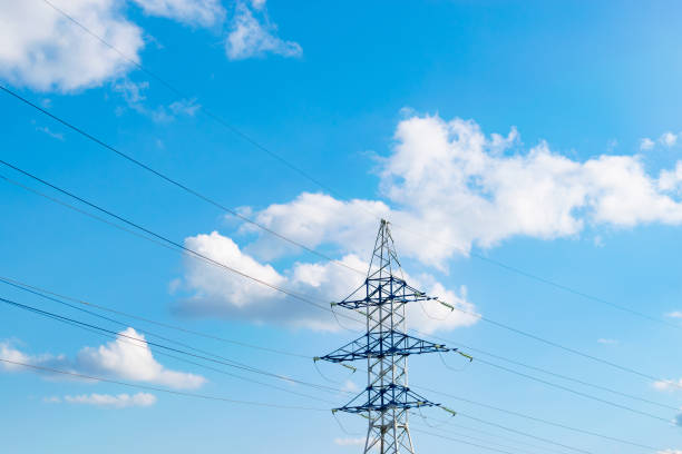 istock power line support against the background of a blue sky with clouds. transmission of electricity and data via wires 2000735173