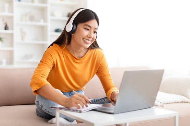 istock Smiling young asian woman studying from home 2000747068