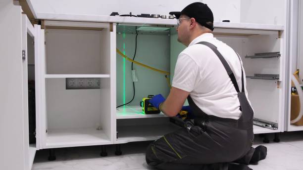 istock A worker installs furniture in the kitchen. The master uses an electronic laser. 2000784187