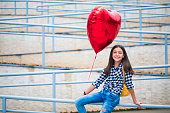 Beautiful girl with heart shape balloon
