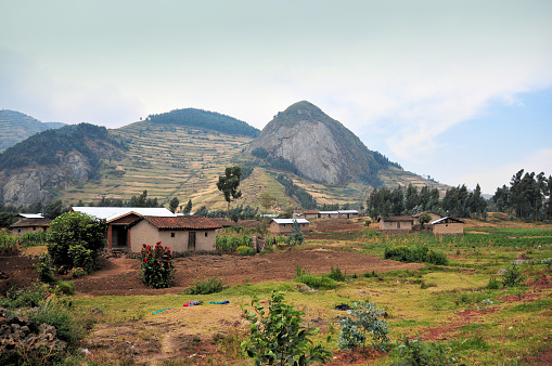 Bigogwe, Nyabihu District, Western Province, Rwanda: Rwandan rural life - Rwandan landscape showcases a quaint village with traditional homes against a backdrop of mountains with terraced fields.