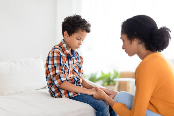 istock Mommy comforting distressed son indoors, holding hands in deep conversation 2000804878