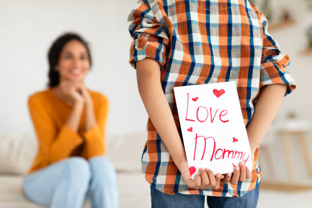 istock Back view of boy presenting Love Mommy card at home 2000804883