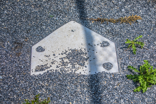 Home plate covered in gravel, shot from above, in a batting cage at a small town baseball field in America.