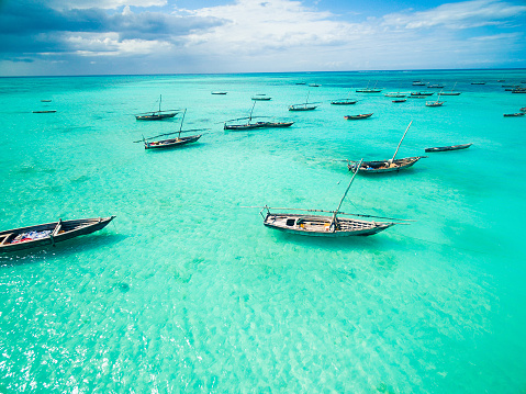 beautiful colorful seascape with african fishing boats in clear ocean, aerial photo