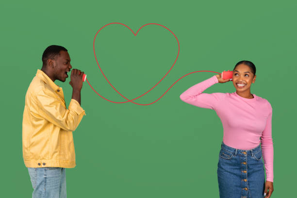 istock Loving man telling romantic words to girlfriend through can phone 2000862461