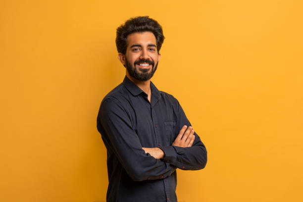 istock Confident young indian man standing arms crossed over yellow background 2000901953