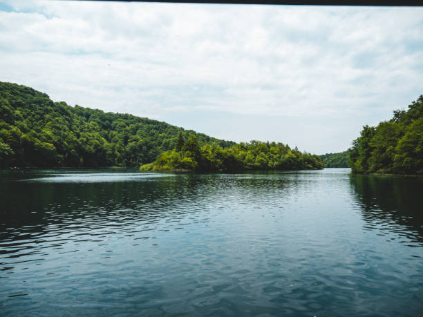 istock Lake surrounded by trees with clouds in the background 2000935311