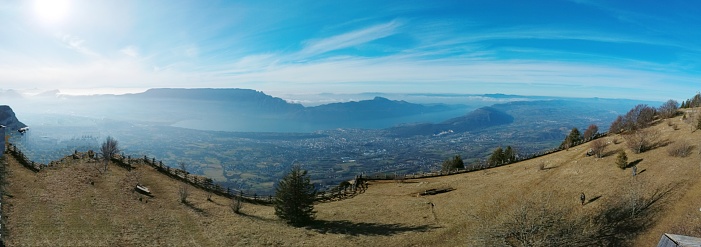 Panoramic France Alps Savoie Mont Revard and clouds sea with sun and blue sky in winter without snow. Aix-les-Bains and Bourget lake