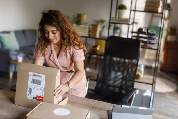 istock Woman opening a cardboard box to pack customer's order 2000994718