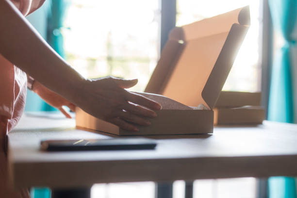 istock Woman opening a cardboard box to pack customer's order 2000994726