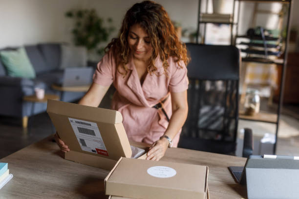 istock Woman opening a cardboard box to pack customer's order 2000994739