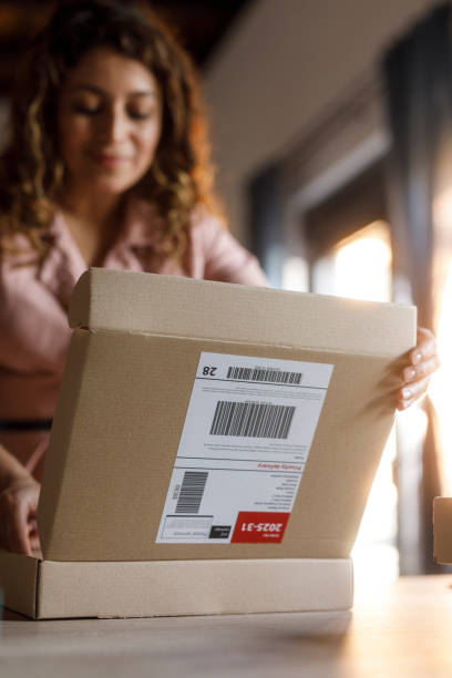 istock Woman opening a cardboard box to pack customer's order 2000994756
