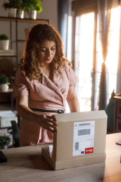 istock Female entrepreneur packing an order at her desk 2000995301