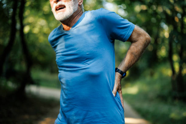 istock Sporty senior man having back pain while jogging 2001089657