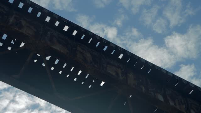 Tight Shot of the Pope Lick Railroad Trestle in Louisville Kentucky from Below, With the Clouds Passing by Against a Blue Sky Above