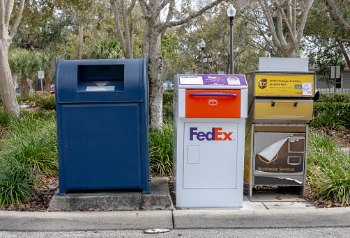 USPS, Fedex and UPS parcel drop boxes in parking lot