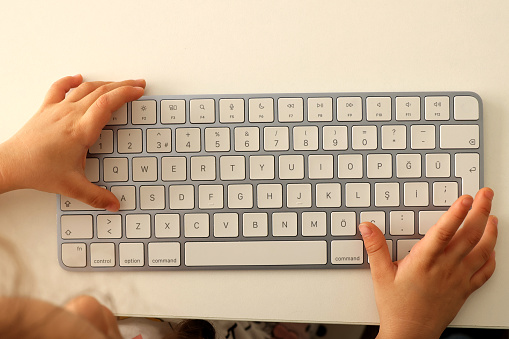 Little girl uses computer keyboard