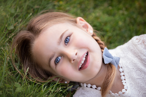 baby girl sitting in grass smiling
