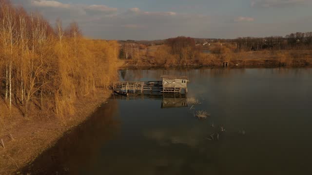 4k aerial top view Small fisherman house near lake. house is on stilts river pond Ukraine