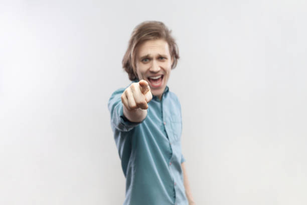 Young Man Posing Playfully in Casual Attire With Green Background in Studio