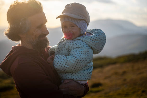 istock Dad with kid hiking in nature at sunset. 2001259168