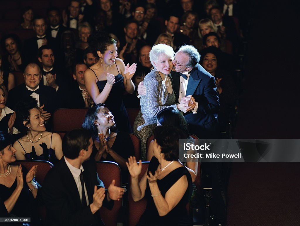 Pubblico applaudire donna matura, marito Baciare la Guancia - Foto stock royalty-free di Cerimonia di premiazione