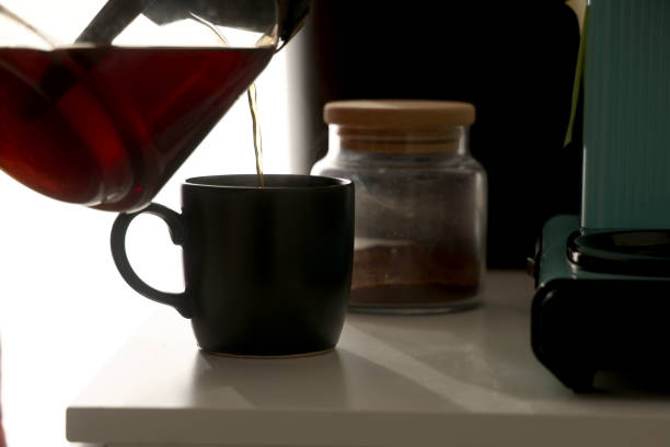 istock Man pours freshly brewed coffee into his glass in the kitchen 2001283591