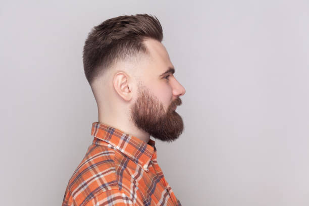 istock Serious strict bearded man standing looking ahead, expressing confidence, wearing checkered shirt. 2001284702
