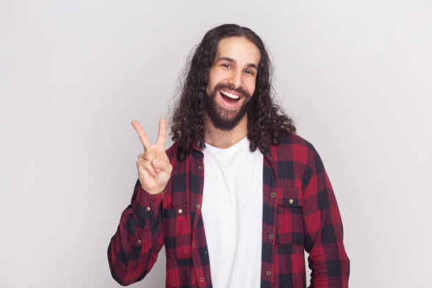 istock Optimistic glad bearded man with positive facial expression, shows V sign or victory gesture. 2001284712
