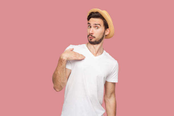 istock Man standing points at himself, has questioned facial expression, asks who me interesting suggestion 2001288009