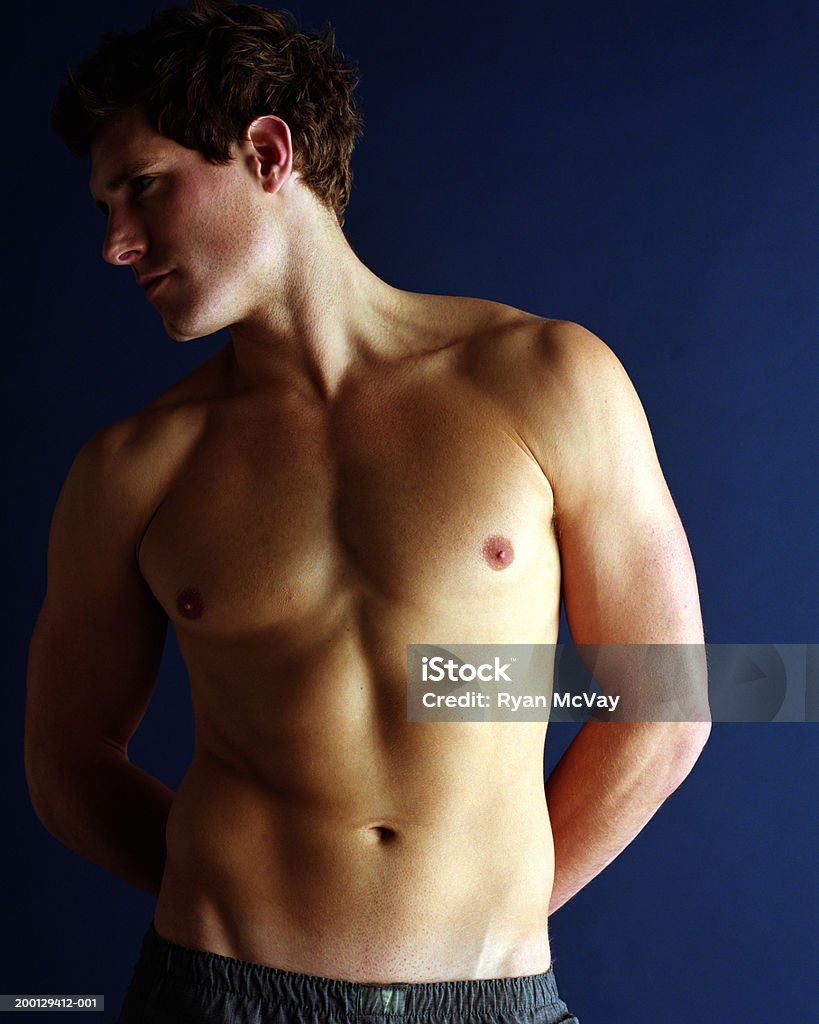 Bare chested man with hands behind back  Brown Hair Stock Photo