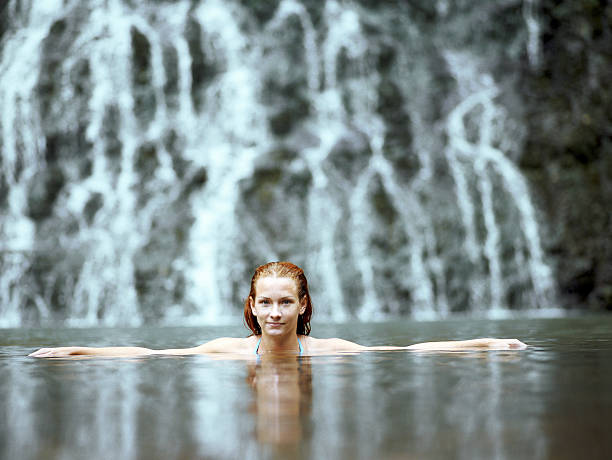 젊은 여성 수영 걸어서 of 카레카레 폴즈, 인물 사진 - karekare falls 뉴스 사진 이미지