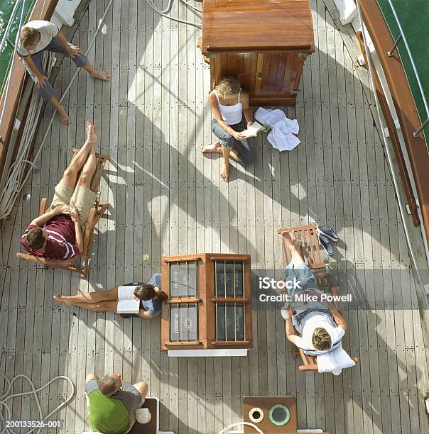 Group Of Friends Reading On Deck Of Sailboat Overhead View Stock Photo - Download Image Now