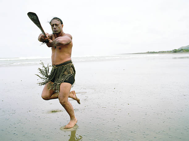 maorys człowiek wykonując taniec haka powhiri na plaży - murawai beach zdjęcia i obrazy z banku zdjęć