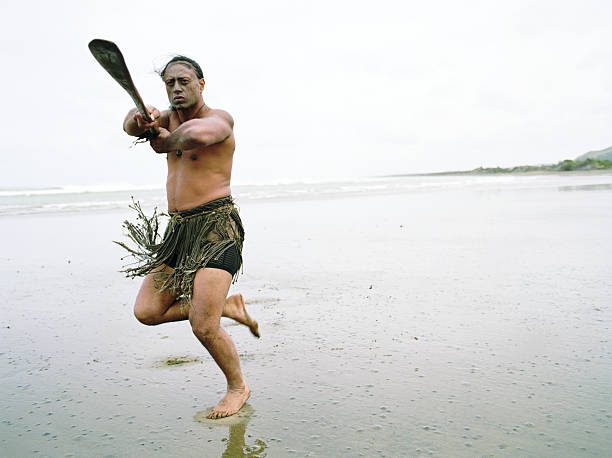 maori homem tocando haka powhiri na praia - murawai beach - fotografias e filmes do acervo